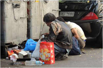 Männer schauen in den Müll / Men looking through rubbish