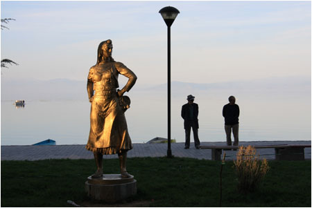 Die goldene Frau am Ufer ist ein Denkmal im sozialistischen Stil. /  The golden lady on the shore is a statue in socialist style.